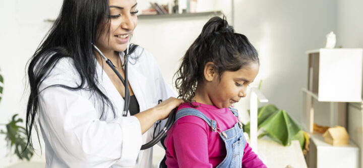 female doctor Hispanic pediatrician auscultating a small child - female doctor Hispanic pediatrician auscultating a small child - health concept -